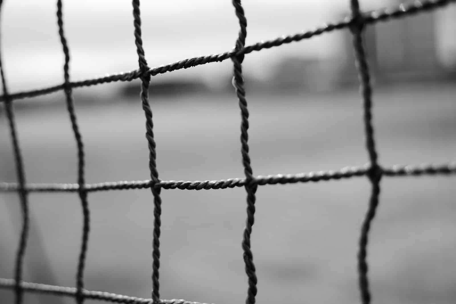 black metal fence in grayscale photography