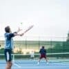 four men playing double tennis during daytime