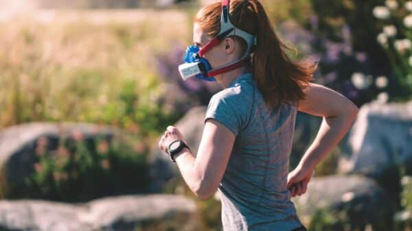 a woman wearing a mask and running in a field