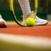 person in white nike sneakers playing tennis