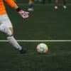 A man kicking a soccer ball on a field