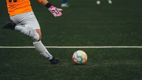 A man kicking a soccer ball on a field