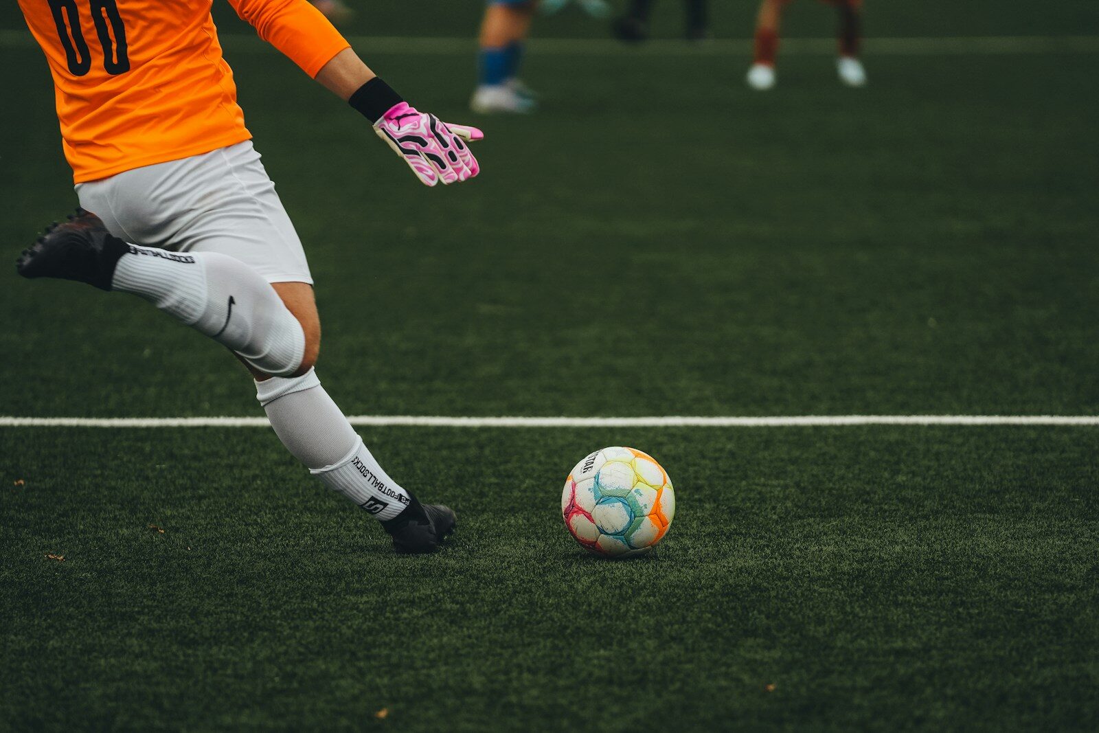 A man kicking a soccer ball on a field