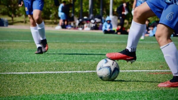 a couple of people that are kicking a soccer ball